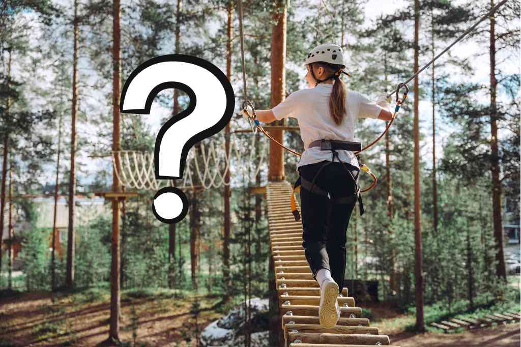 Tüdruk ronib seikluspargis. Suur valge küsimärk. Mis on seikluspark?